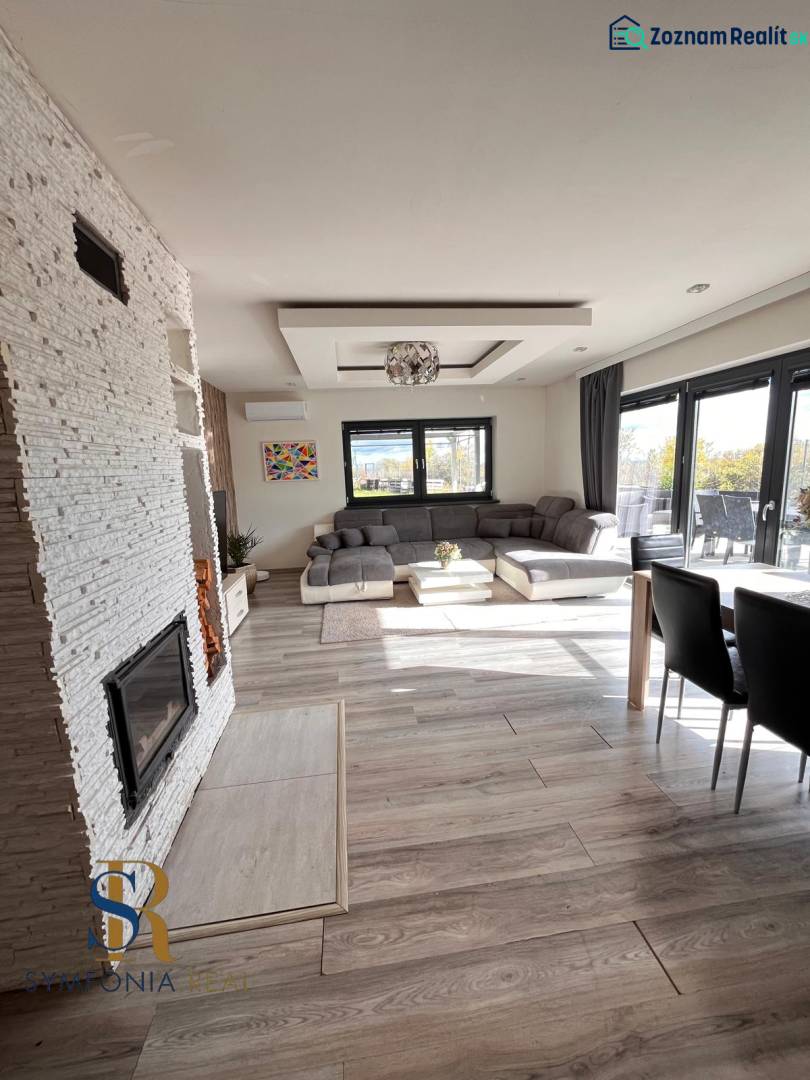 Innenraum eines Einfamilienhauses mit Sofa, Kamin und Holzboden.