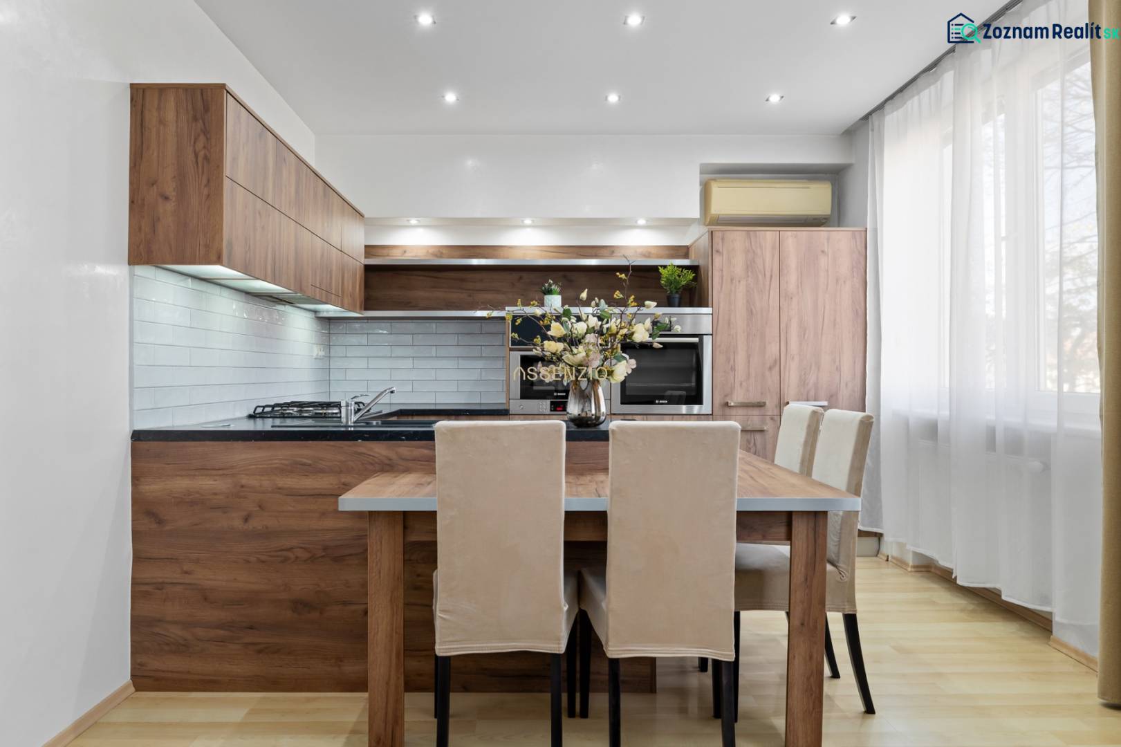 Küche in einer 2-Zimmer-Wohnung mit Holzdekor und hellen Möbeln.