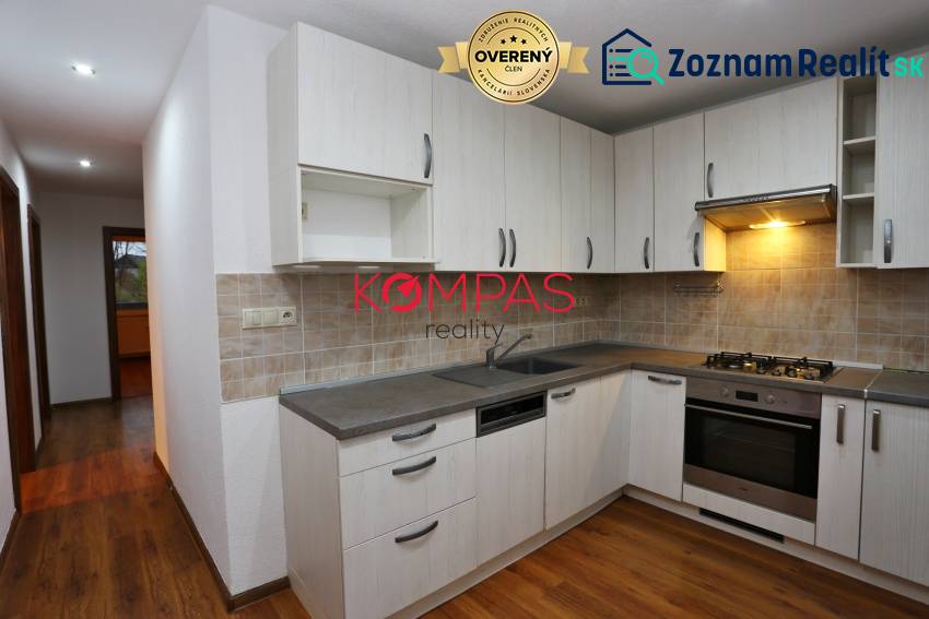 Küche mit Küchenzeile und Holzboden in einer 3-Zimmer-Wohnung.