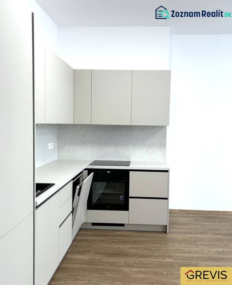 Küche in einer 4-Zimmer-Wohnung mit Holzboden und weißen Schränken.