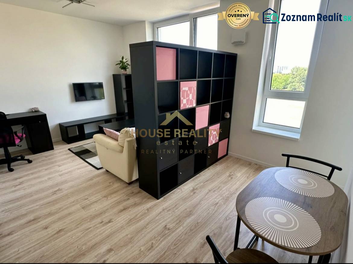 Wohnzimmer in einer 2-Zimmer-Wohnung mit Regalwand und Boden in Holzoptik.