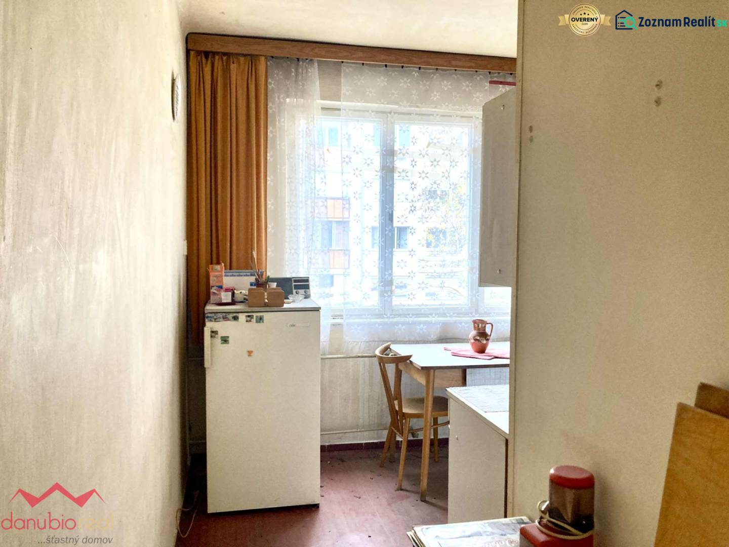 Küche in einer 3-Zimmer-Wohnung mit Holzboden, einfacher Einrichtung und Fenster.