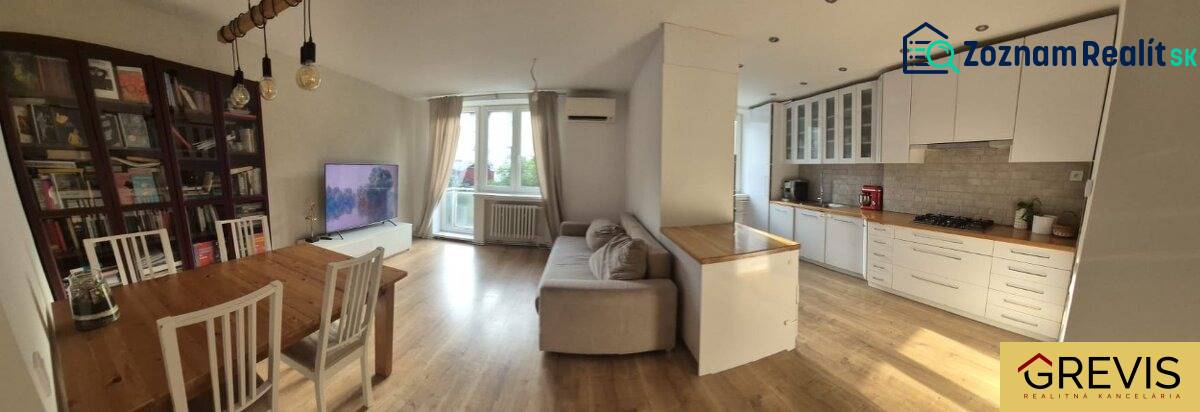 Geräumige Küche mit Wohnzimmer in einer 3-Zimmer-Wohnung. Boden mit Holzdekor, helle Möbel.