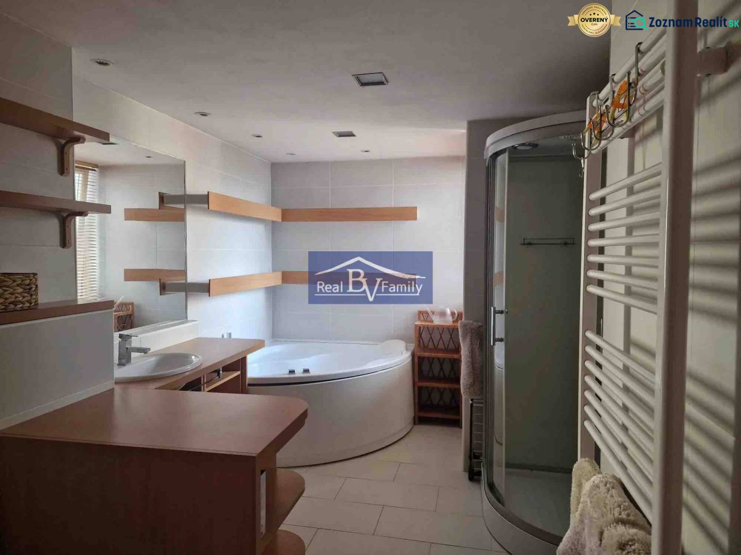 Badezimmer in einer 2-Zimmer-Wohnung, mit Badewanne, Dusche und Regalen.