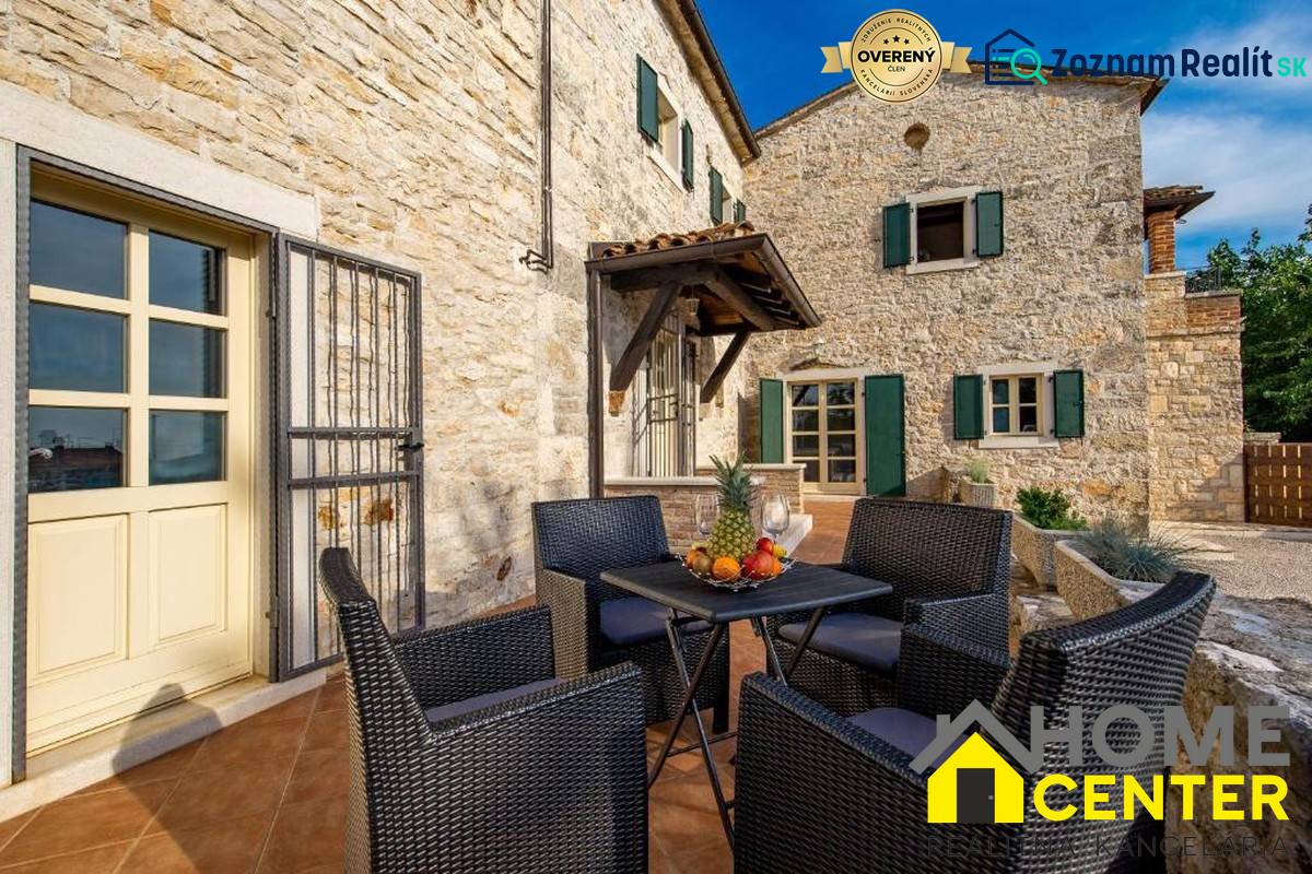 Steinfassade der Villa in Bale mit Außensitzbereich und Obst auf dem Tisch.