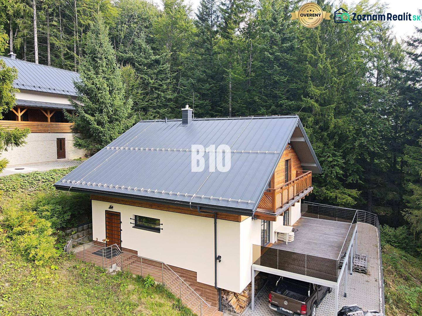 Eine Hütte in Terchová, umgeben von Wäldern, mit großer Terrasse und Parkplatz.