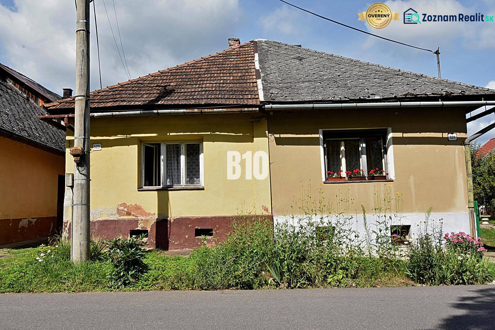 Ein gelbes Einfamilienhaus in Partizánska Ľupča mit einem schrägen Dach und einem angrenzenden Garten.