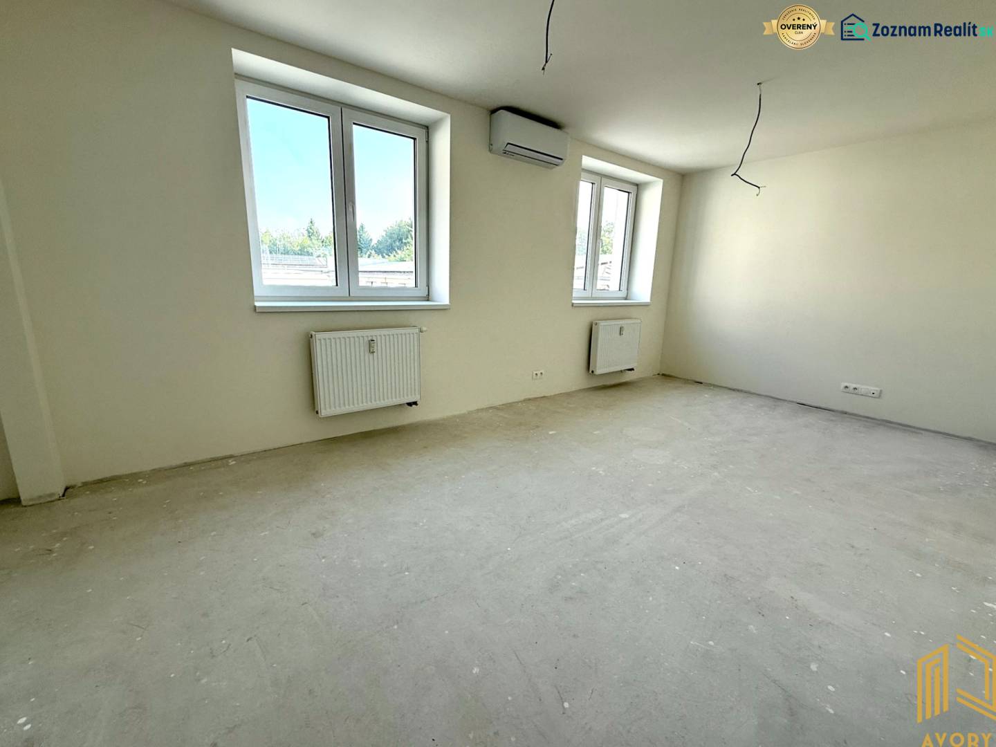 Geräumiges Zimmer in einer 2-Zimmer-Wohnung mit großen Fenstern und neutralen Wänden.