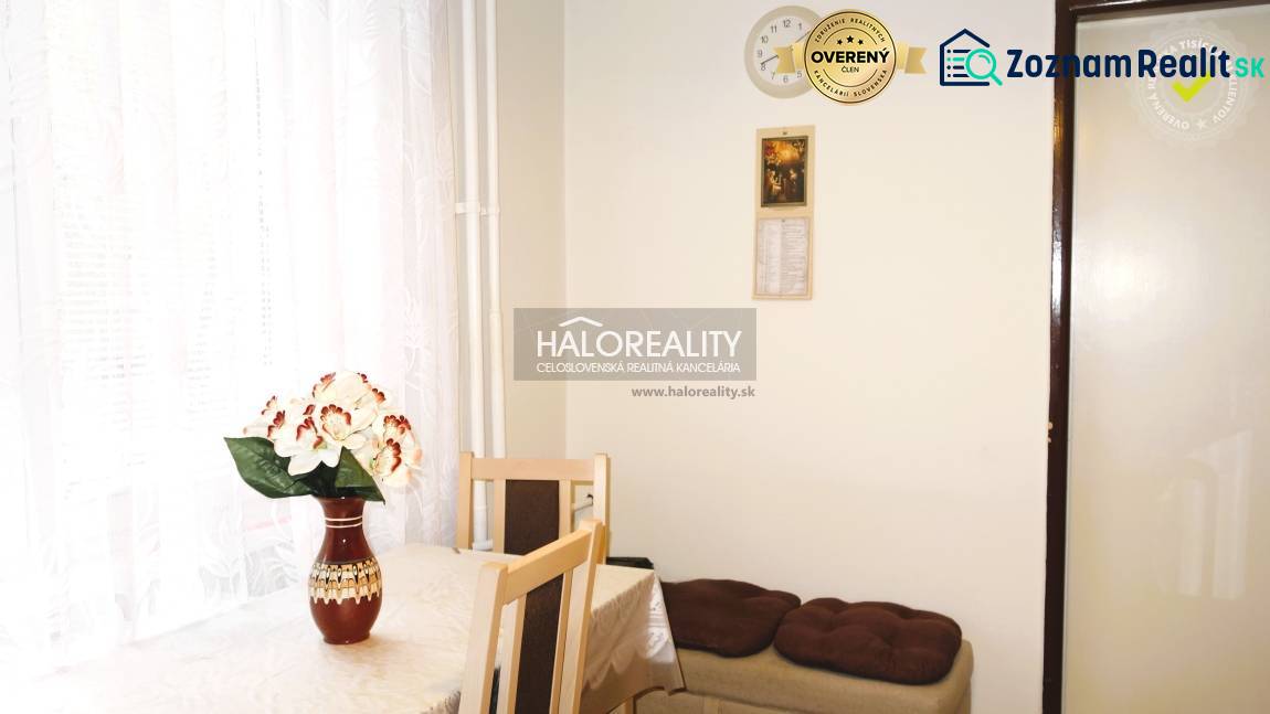 Essbereich in einer 3-Zimmer-Wohnung mit einer Blume auf dem Tisch und einem weißen Vorhang.