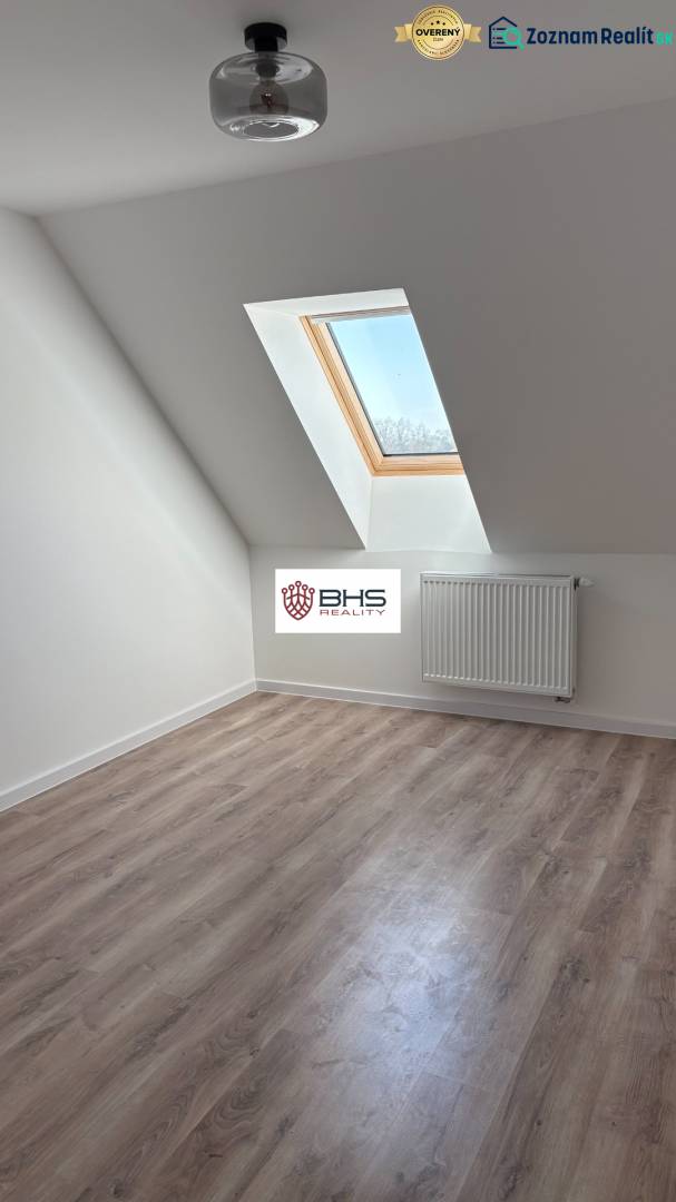 Dachgeschosszimmer mit Holzboden und Dachfenster in einer 3-Zimmer-Wohnung.