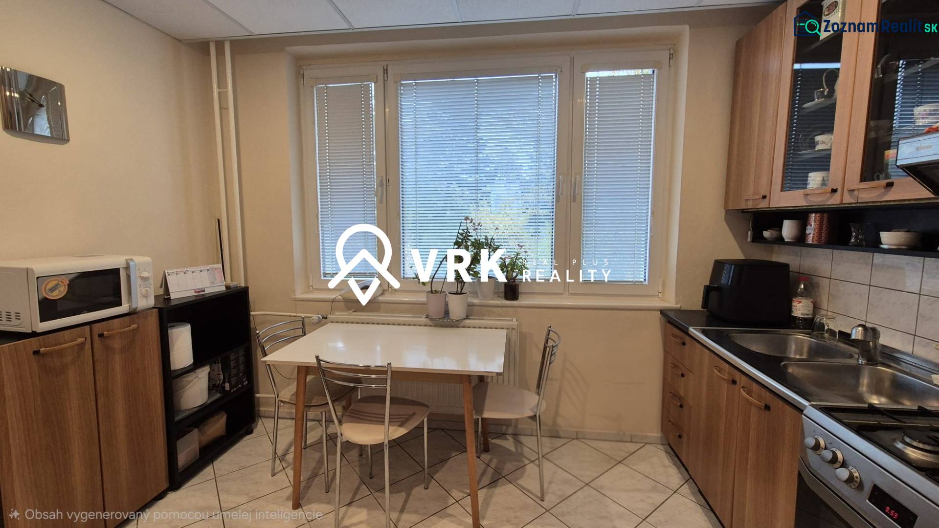 Küche einer 3-Zimmer-Wohnung mit Esstisch, Küchenzeile und Mikrowelle.