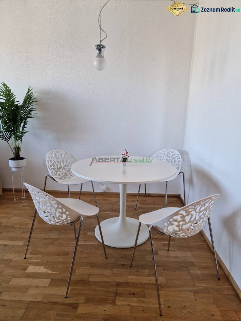 Essbereich in einer 3-Zimmer-Wohnung mit Holzboden und dekorativen Stühlen.