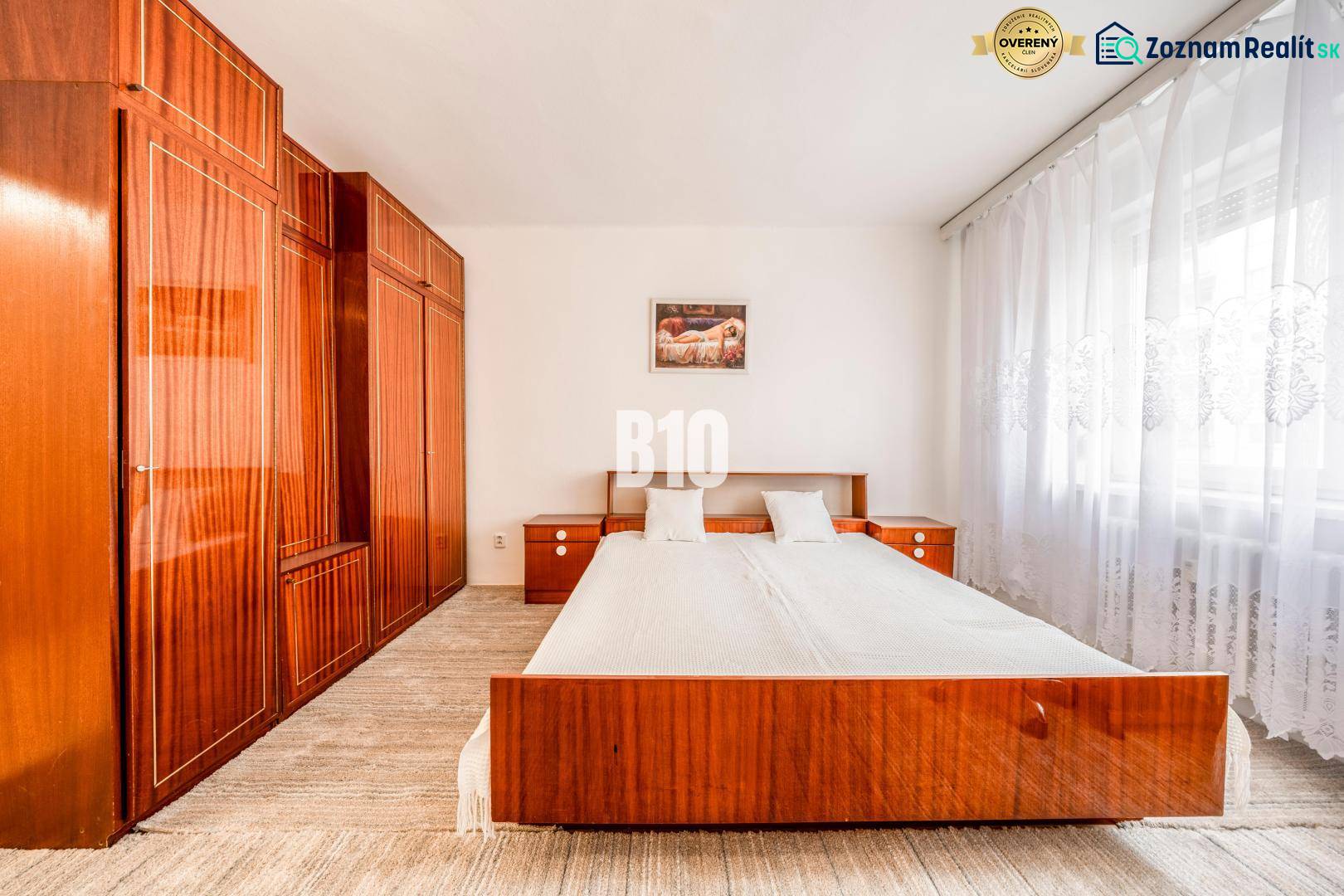 Schlafzimmer in einer 4-Zimmer-Wohnung mit Doppelbett und Einbauschränken, helle Vorhänge.