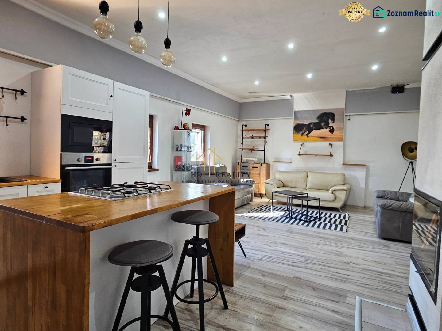 Innenraum eines Einfamilienhauses mit Küchenzeile, Holzboden und bequemen Sitzgelegenheiten.