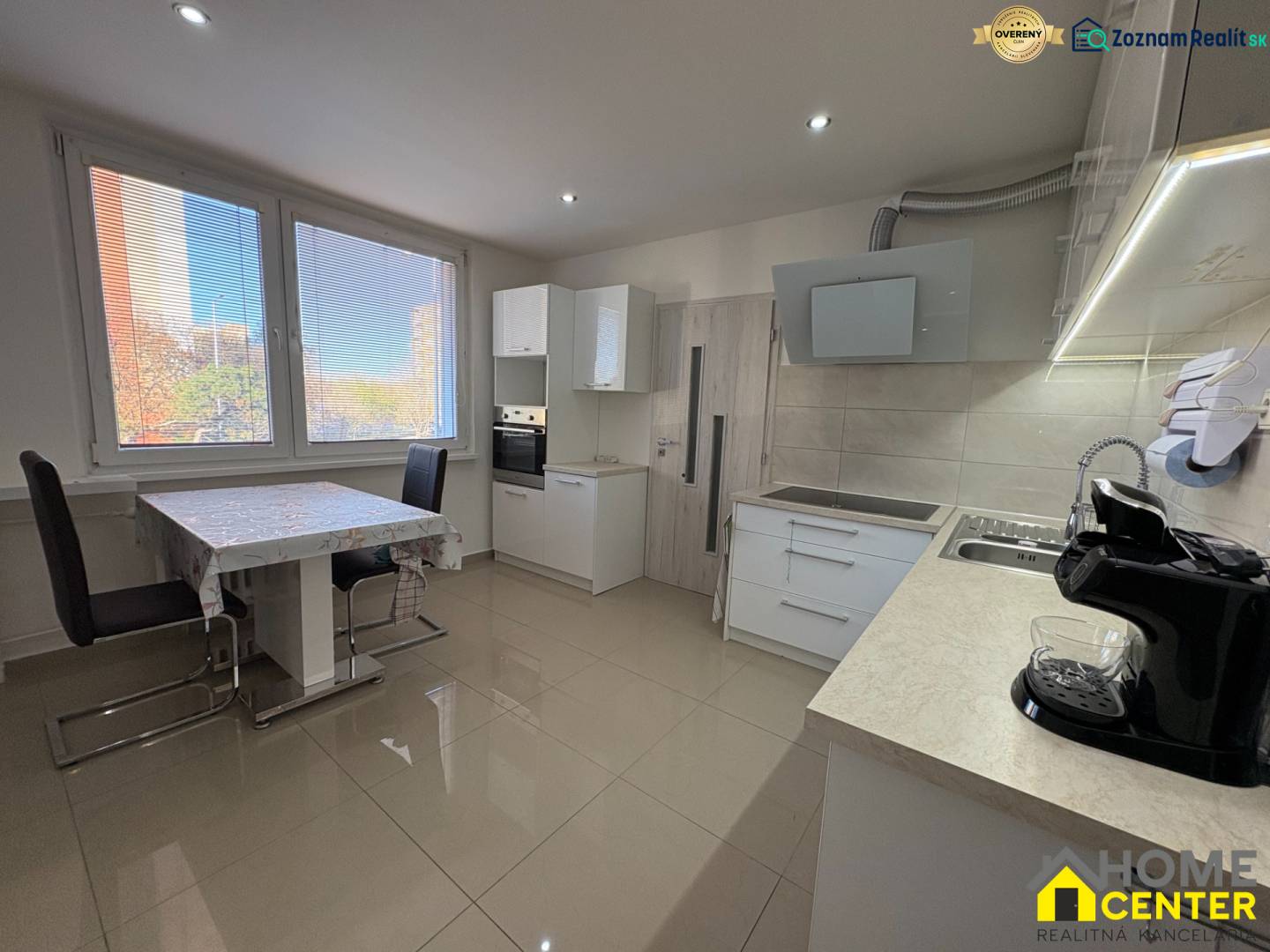 Küche einer 3-Zimmer-Wohnung mit großen Fenstern, Esstisch und hellem Boden.