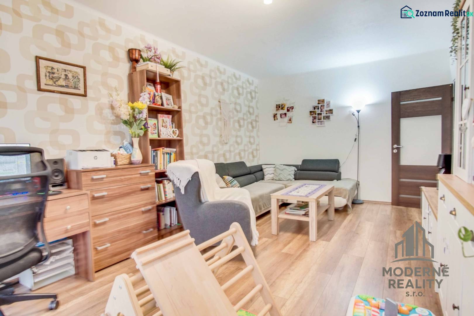 Wohnzimmer in einer 3-Zimmer-Wohnung mit Holzboden, bequemer Couch und Dekorationen.