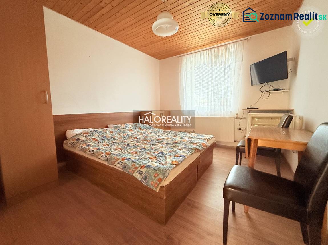 Ein Zimmer in Hotels und Pensionen mit einem Bett, einem Tisch und einem Boden mit Holzdekor.