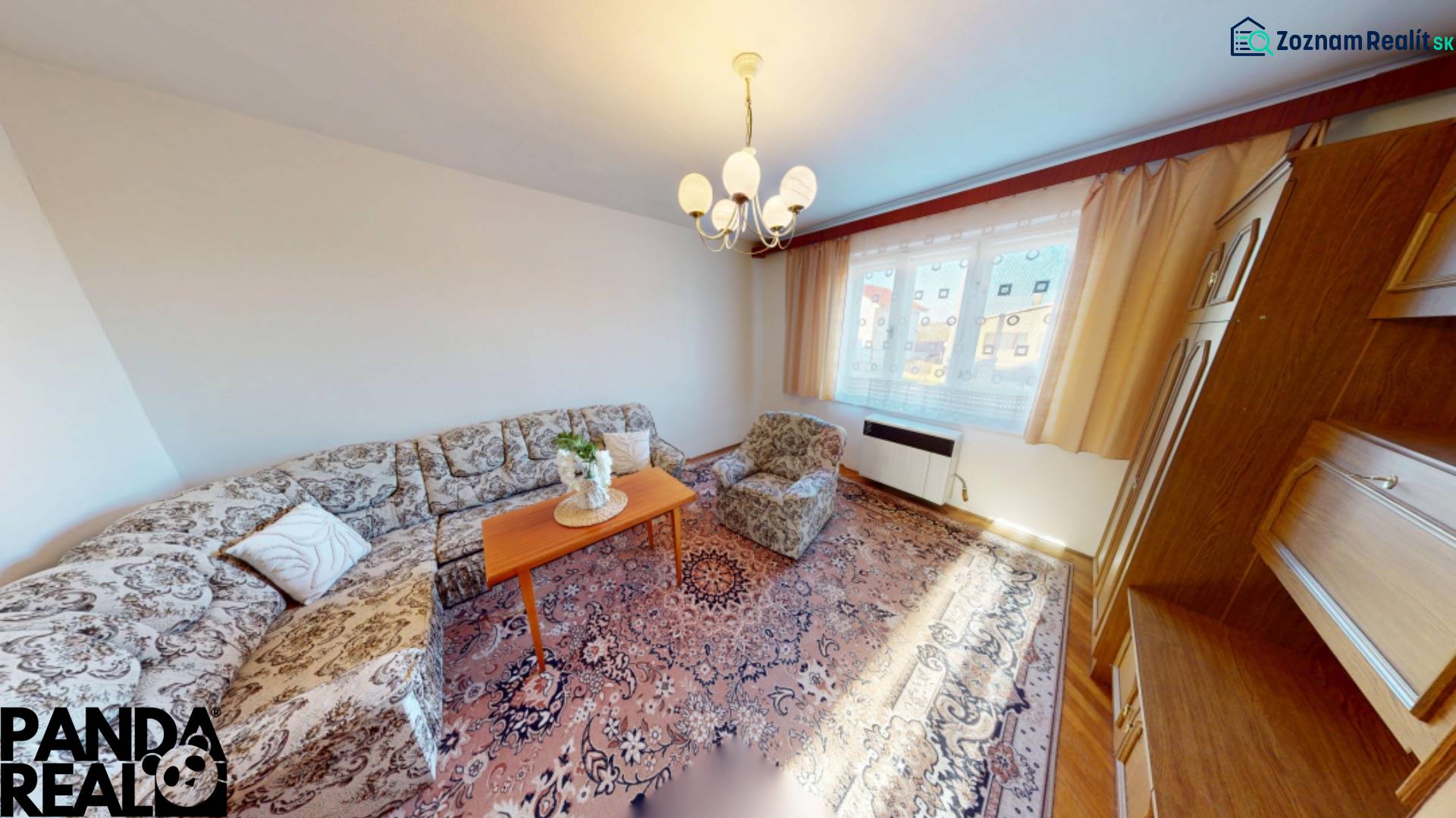 Wohnzimmer in einem Einfamilienhaus mit Sofa, Teppich und Holzschränken.