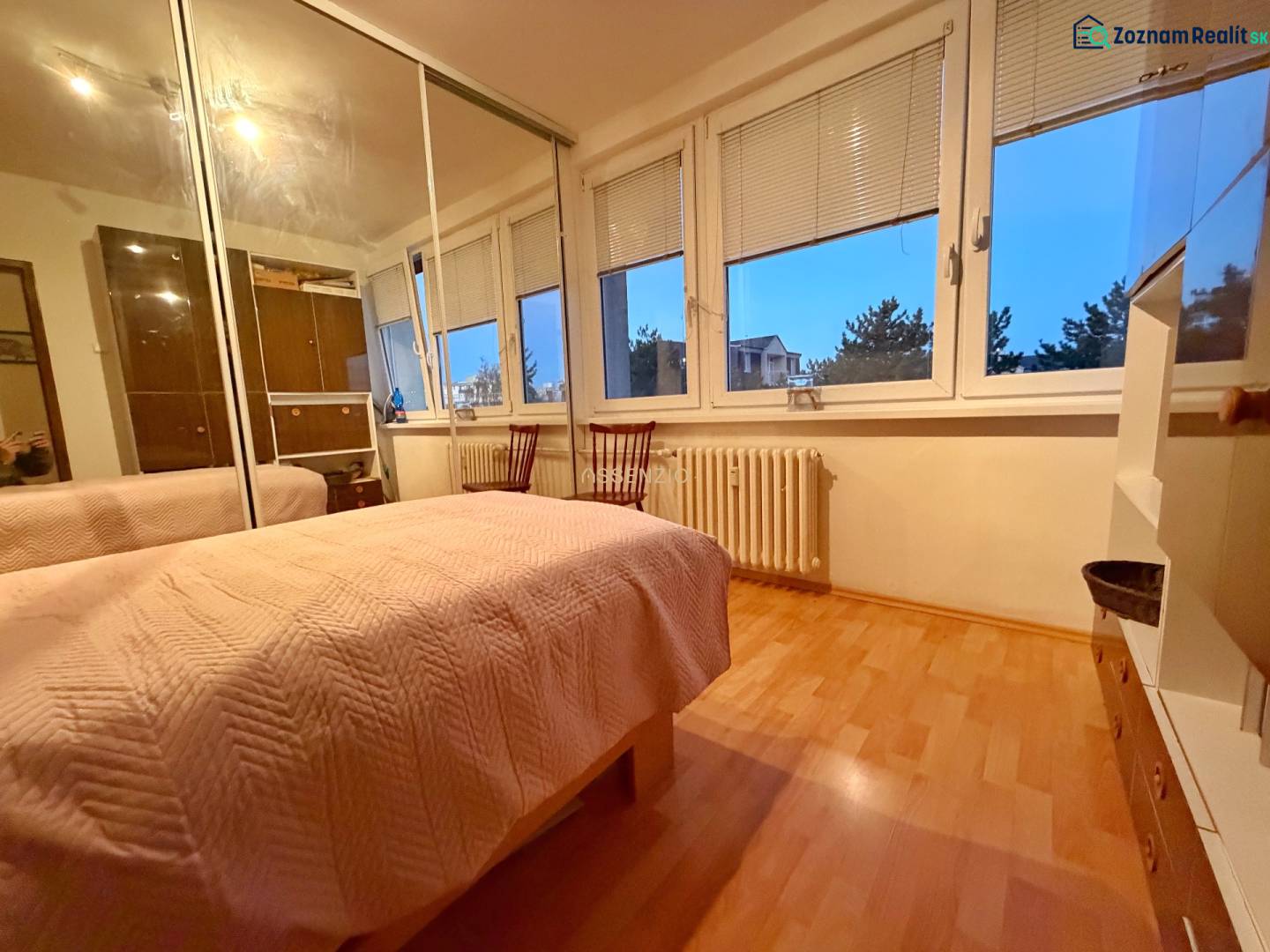 Schlafzimmer in einer 3-Zimmer-Wohnung mit Bett, Schrank und Boden in Holzoptik.