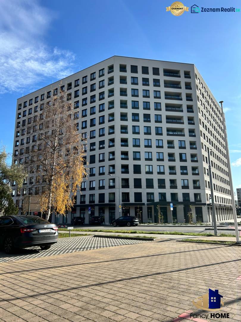 Wohnhaus in der Karpatská-Straße in Poprad, umliegender Parkplatz und Bäume.