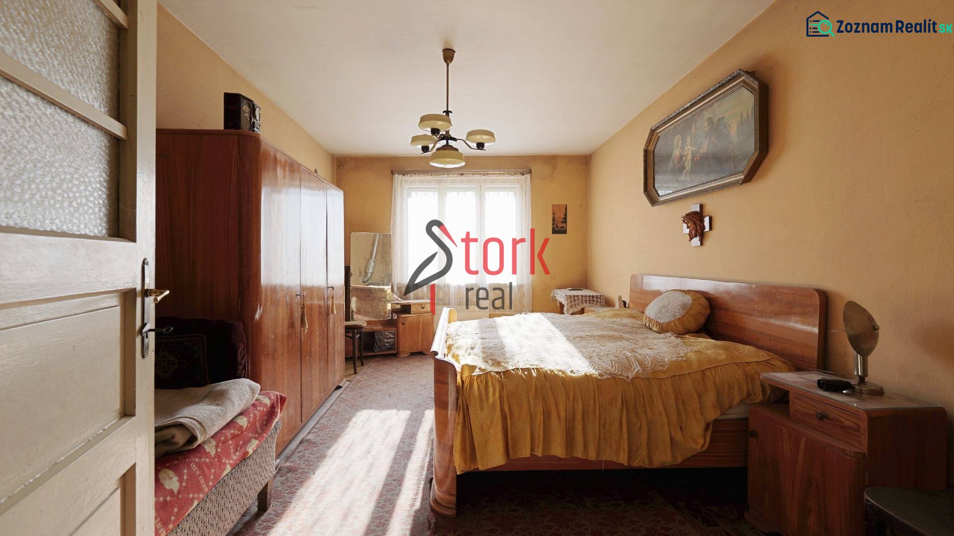 Schlafzimmer im Einfamilienhaus mit Möbeln, Kronleuchter und Bild an der Wand.