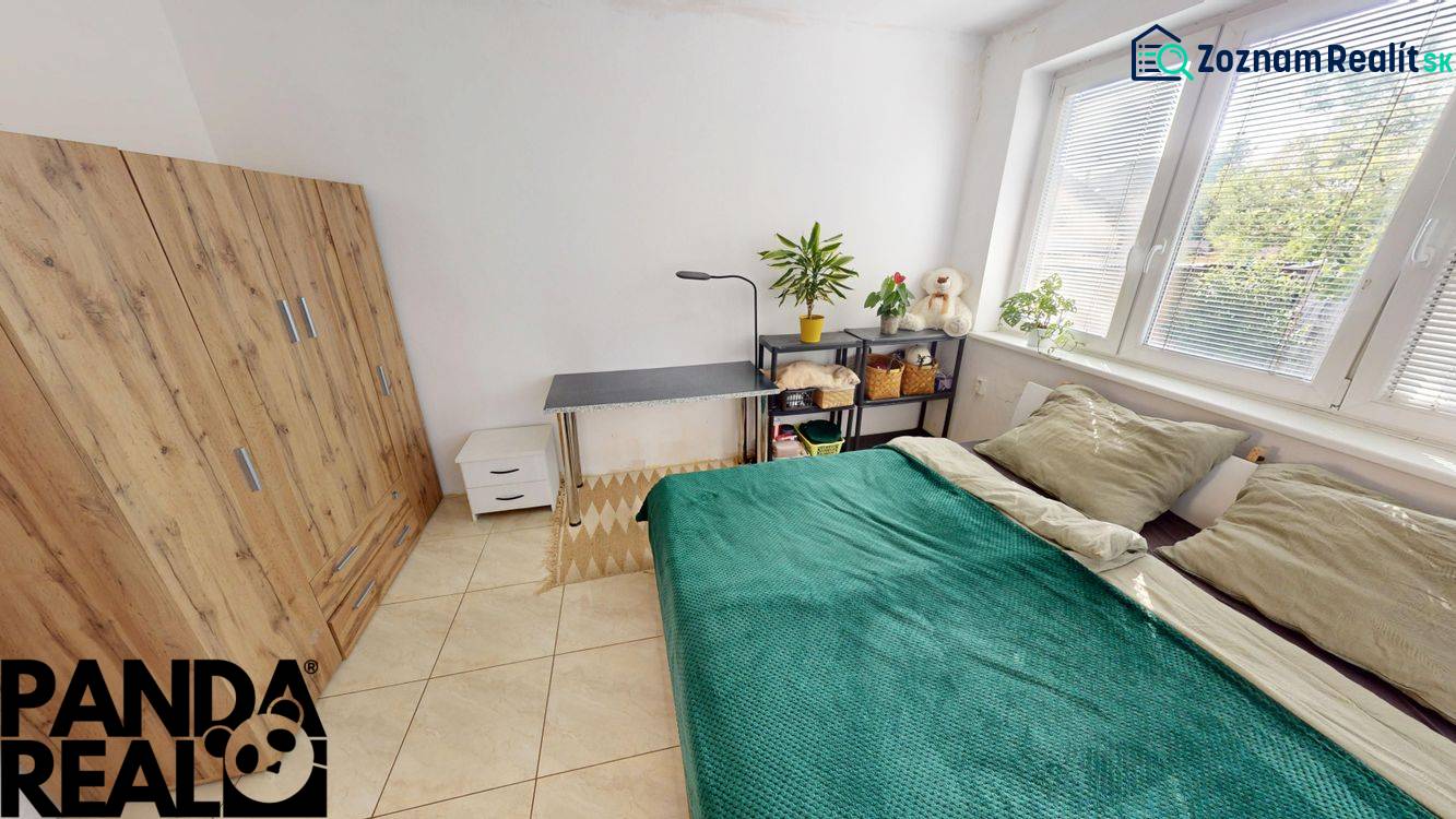 Schlafzimmer in einer 3-Zimmer-Wohnung mit Bett, Schreibtisch und Schrank mit Holzdekor.