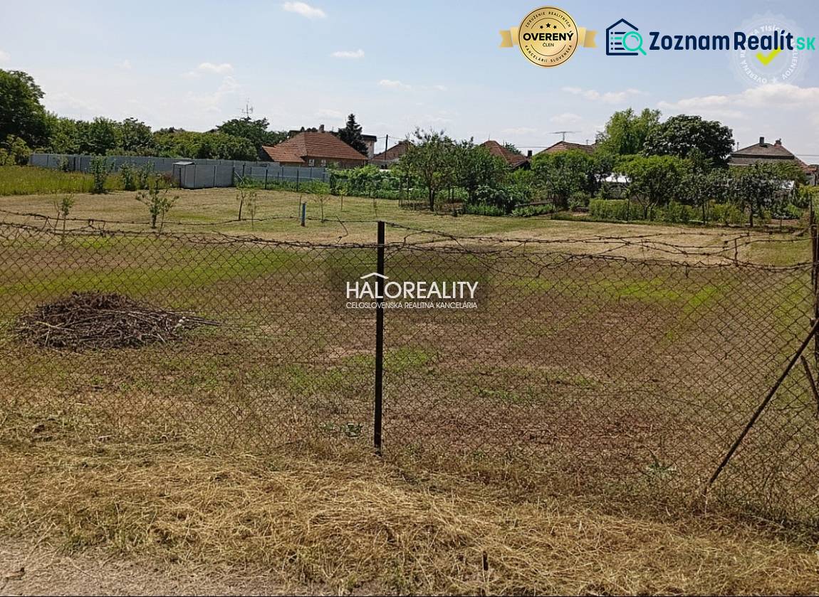 Gärten in Marcelová mit Rasenfläche und Umzäunung, Bäume im Hintergrund.