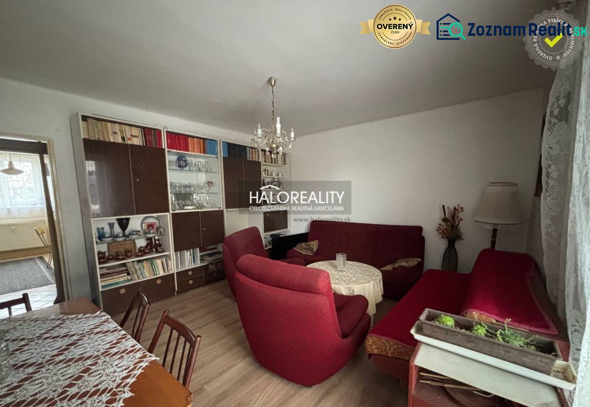 Wohnzimmer in einer 3-Zimmer-Wohnung mit Holzboden und roten Sesseln.