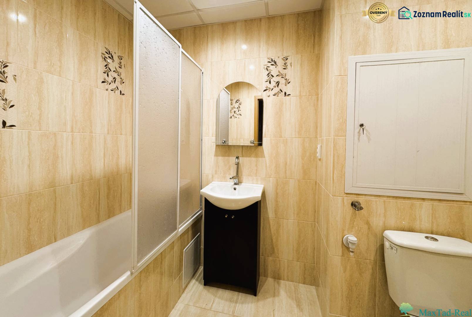 Badezimmer mit Badewanne, Waschbecken und Toilette in einer 3-Zimmer-Wohnung mit hellen Fliesen.