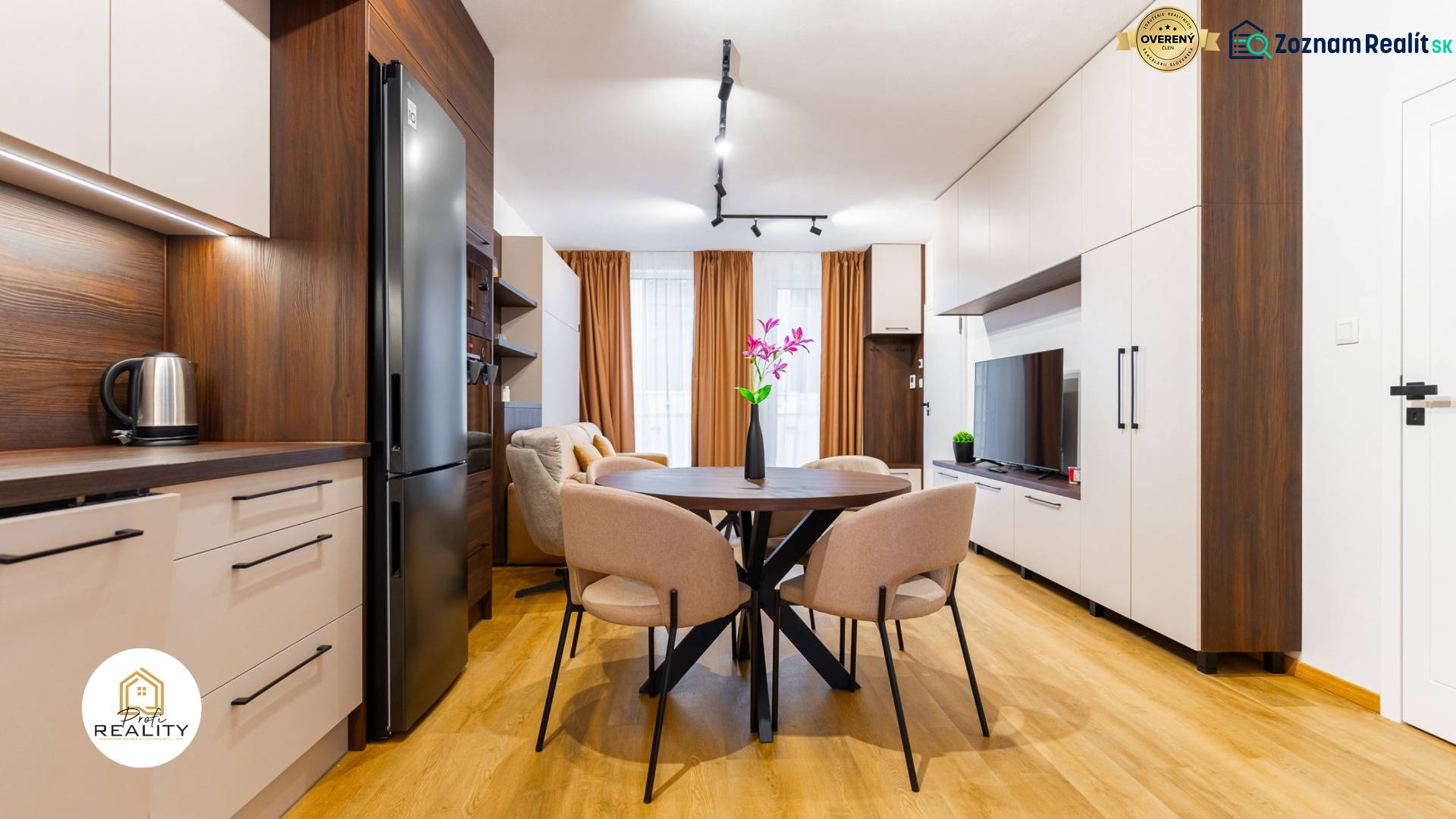 Innenraum einer Einzimmerwohnung mit Holzboden, Küche und Esstisch.