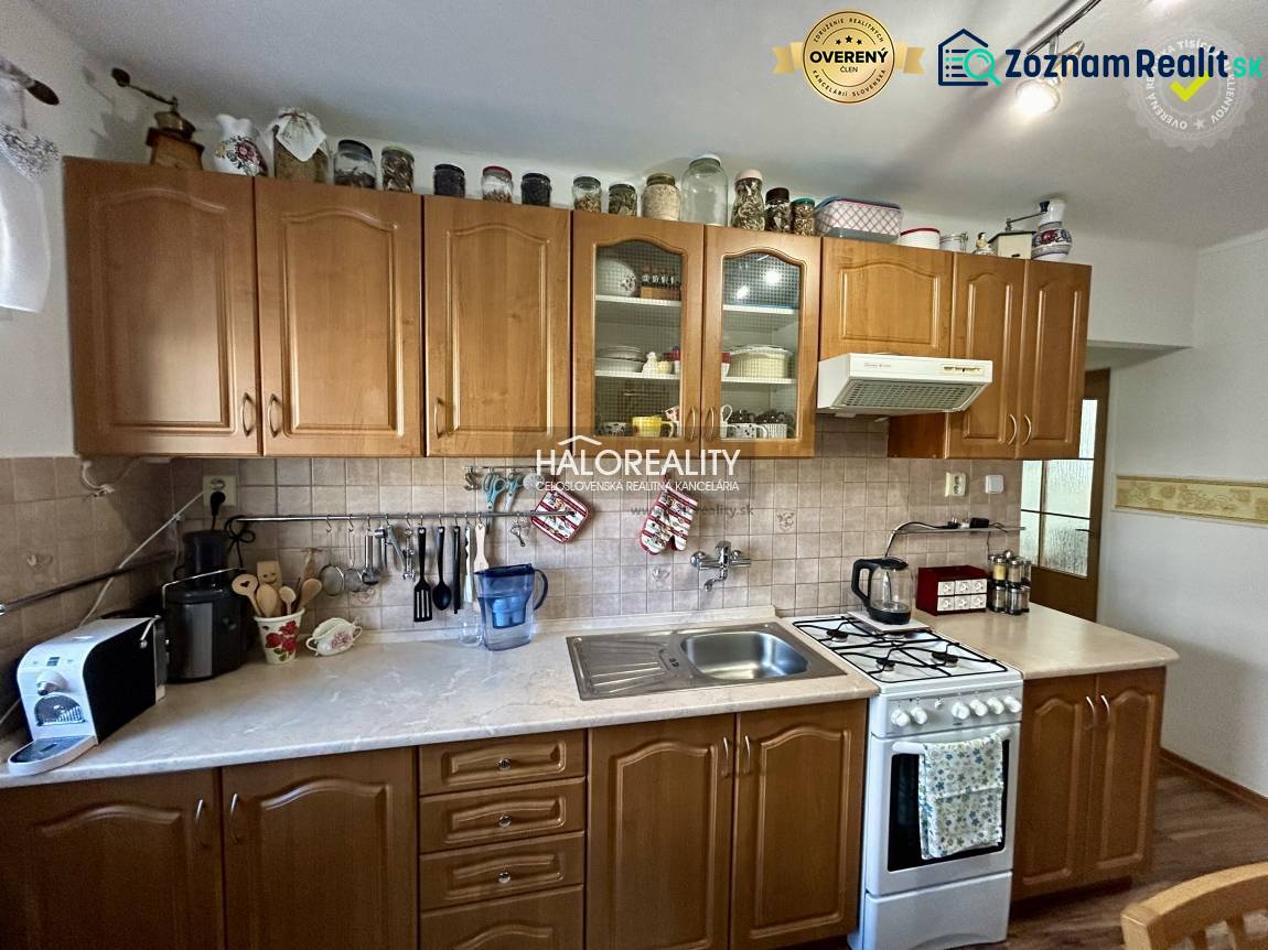 Küche in einer 2-Zimmer-Wohnung mit Holzboden und Holzschränken.