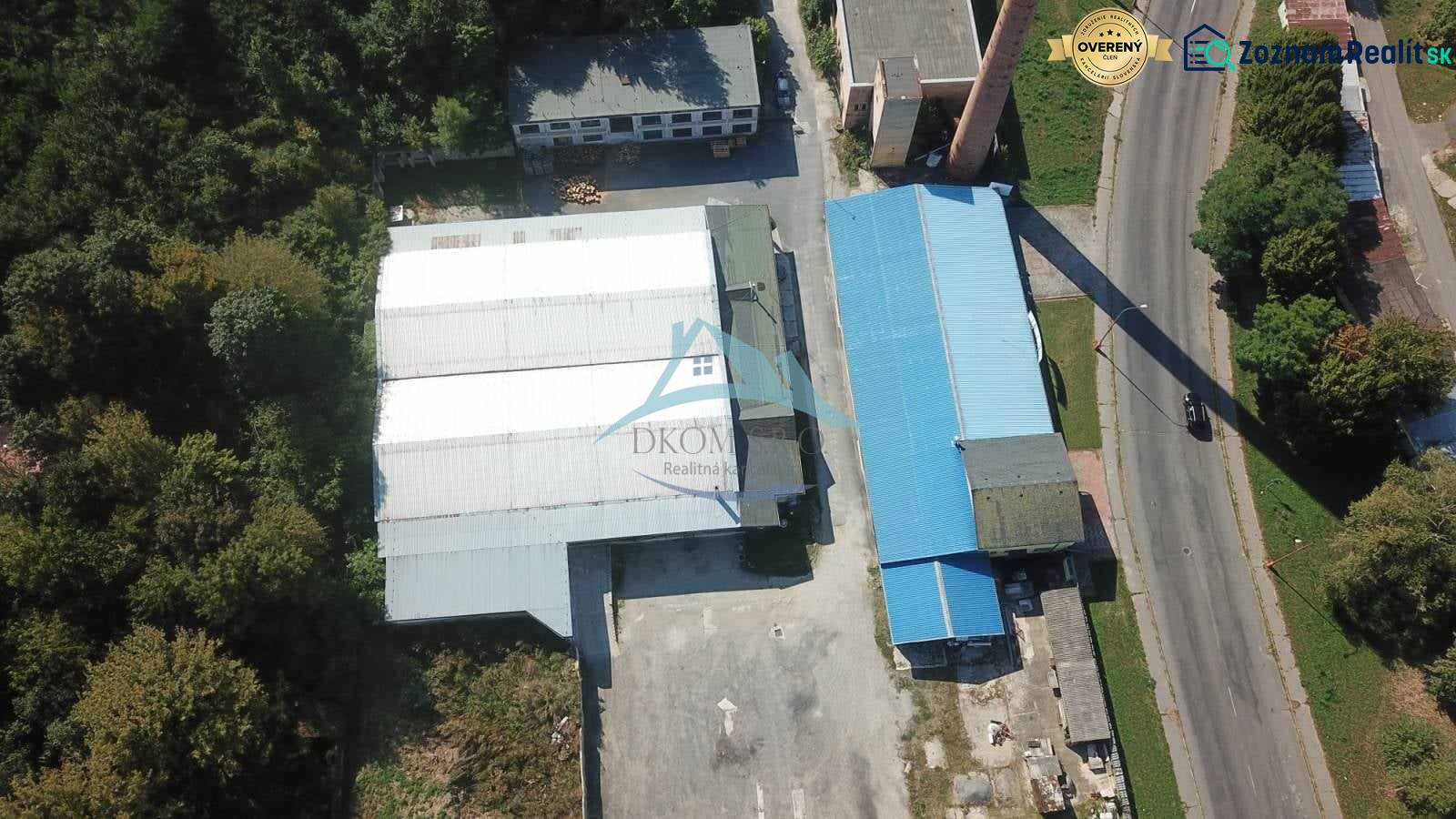 Luftaufnahme von Hallen und Lagern in der Nähe der Straße Železničná, umgeben von Grünflächen und Grundstücken.