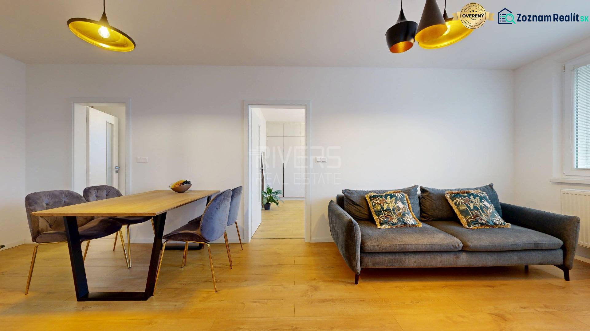 Wohnzimmer einer 3-Zimmer-Wohnung mit Salon, Esstisch und Holzboden.