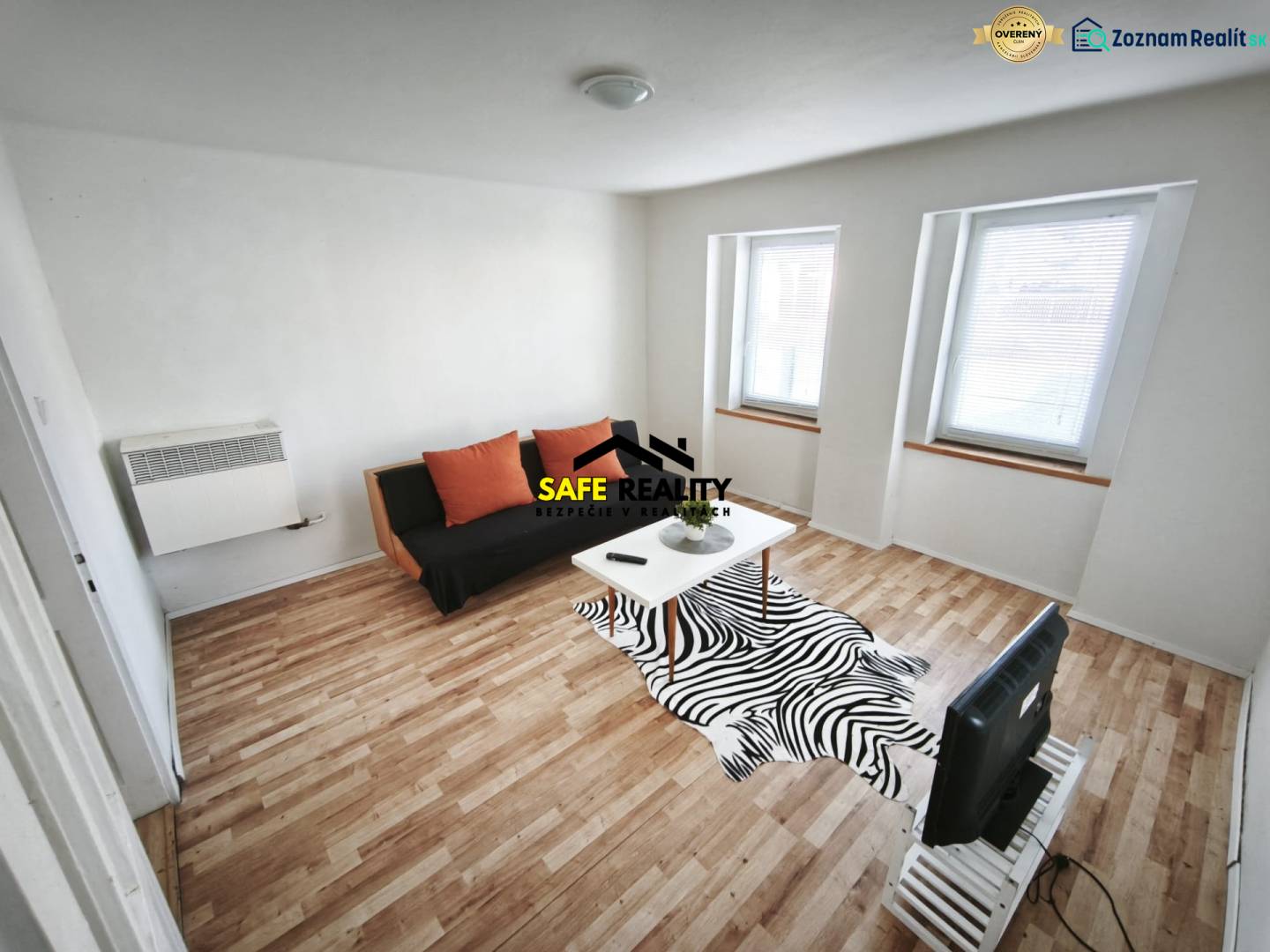 Wohnzimmer in einem Einfamilienhaus mit Sofa, Tisch und Holzboden.