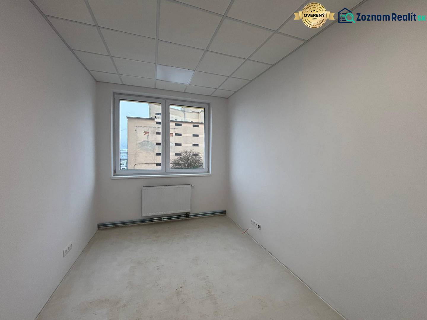 Büro in Weiß mit Heizkörper und Blick aus dem Fenster.