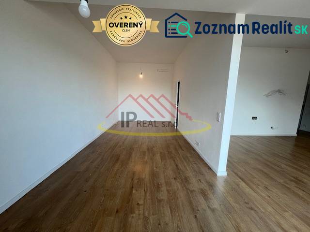 Ein Zimmer mit Holzboden in einer 2-Zimmer-Wohnung, neutrale Wände.