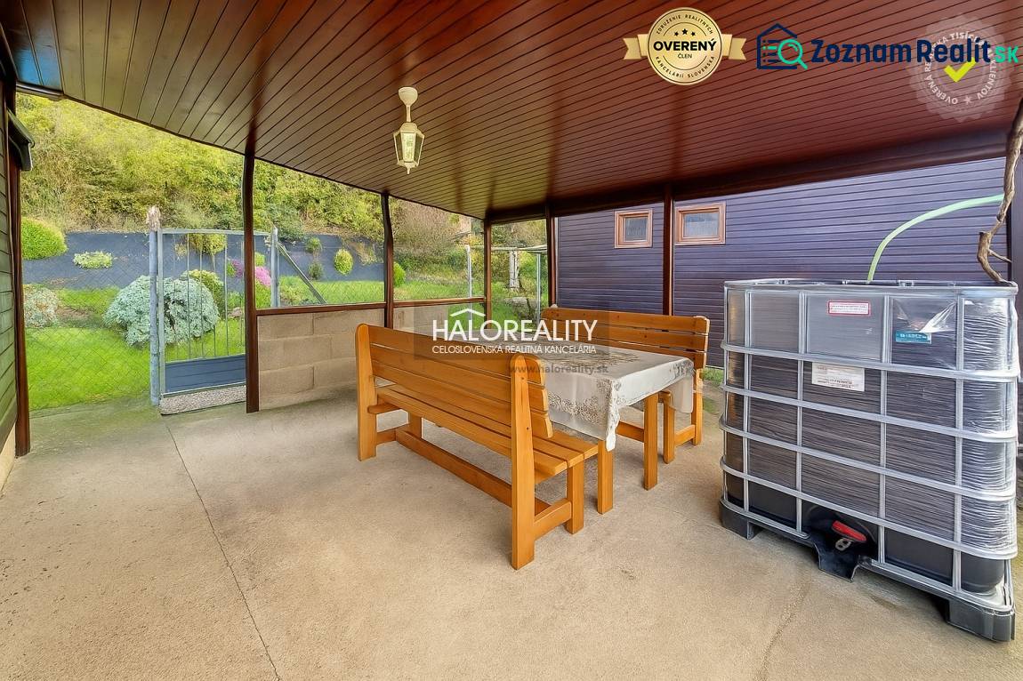 Überdachte Terrasse mit Tisch, Bänken und Blick auf die Gärten in Bytča.