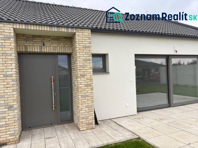 Einfamilienhaus in der Fialkova in Tomášov mit Ziegelverkleidung und geräumigen Glastüren.