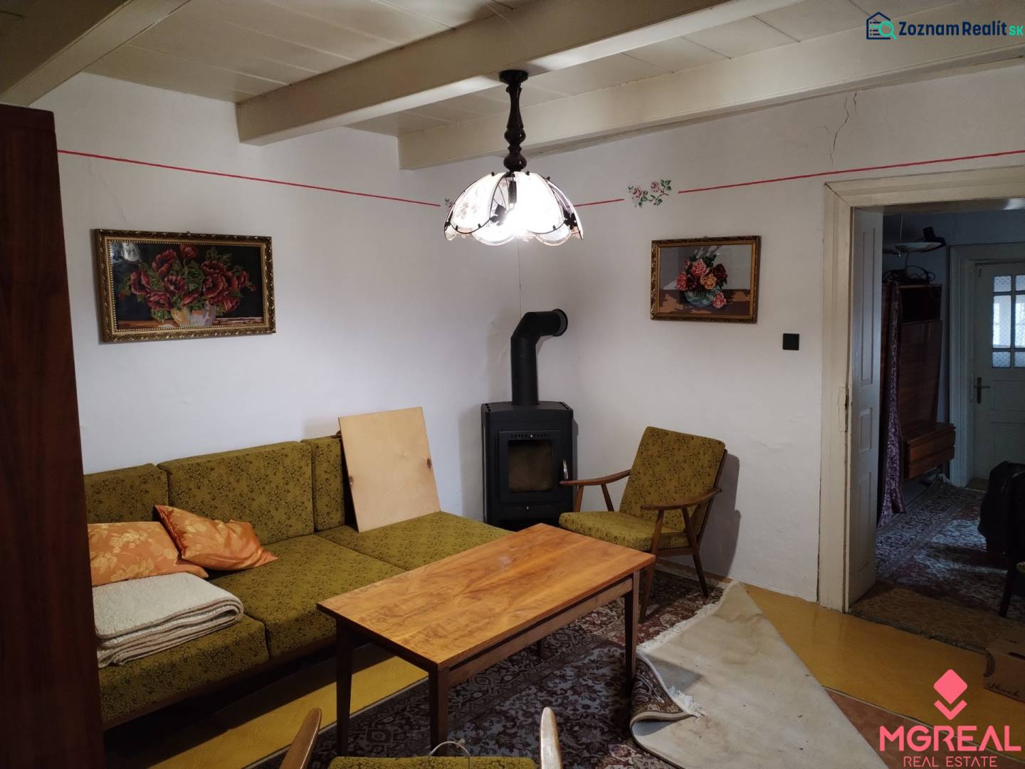 Wohnzimmer eines Einfamilienhauses mit Kachelofen, antiken Möbeln und Dekorationen.