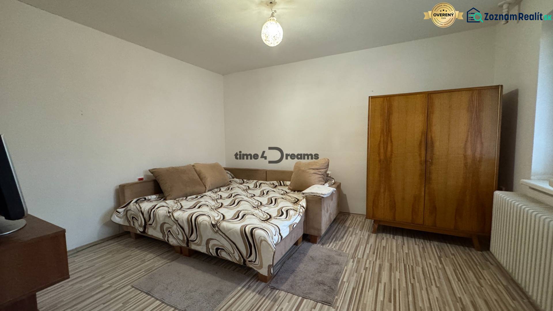 Schlafzimmer eines Einfamilienhauses mit Bett, Kleiderschrank und Boden in Holzoptik.