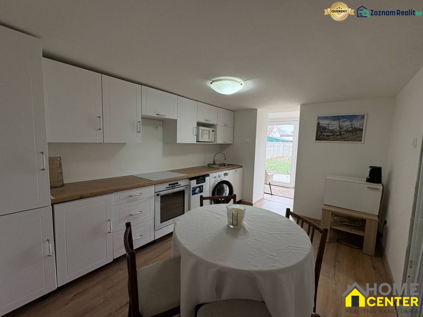 Küche in einer Einzimmerwohnung mit Holzboden und Esstisch.