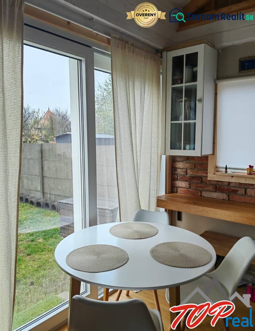 Essbereich in einem Einfamilienhaus mit Holzboden, Ziegelwand und großen Fenstern.