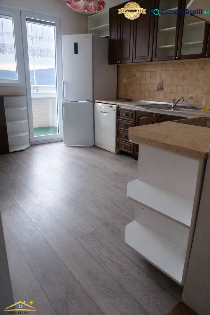 Küche in einer 3-Zimmer-Wohnung mit Holzboden, weißem Kühlschrank und Geschirrspüler.