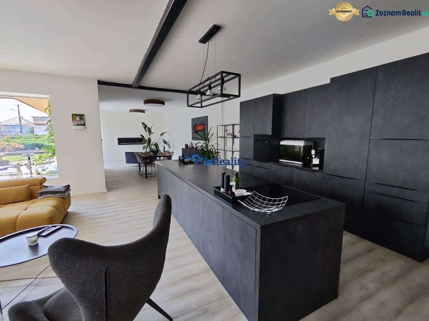 Wohnzimmer verbunden mit Küche in einem Einfamilienhaus mit Holzboden.