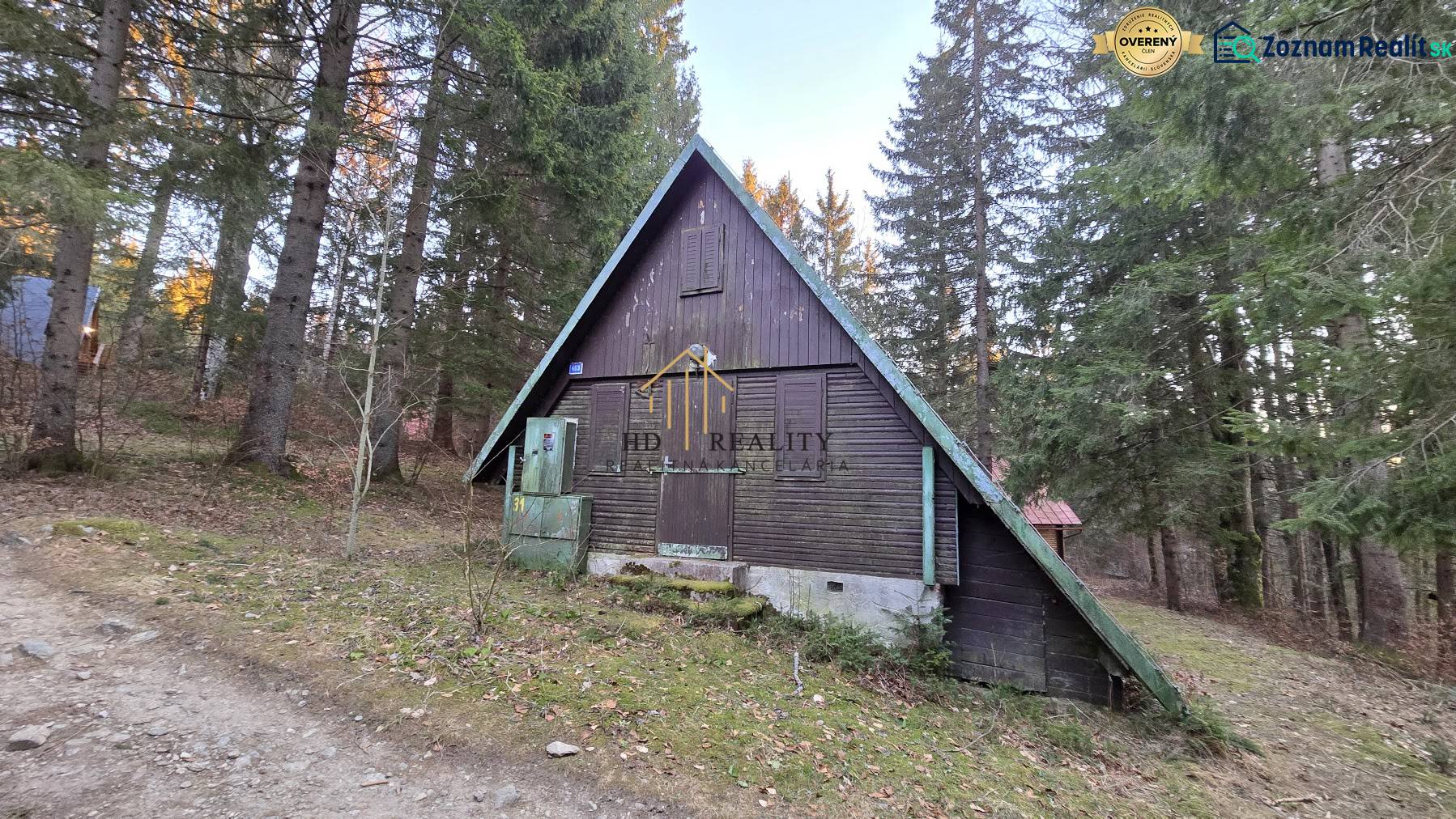 Eine Hütte in Krpáčovo, eingetaucht im Wald, sichtbar ist die Holzkonstruktion und die Umgebung mit Nadelbäumen.
