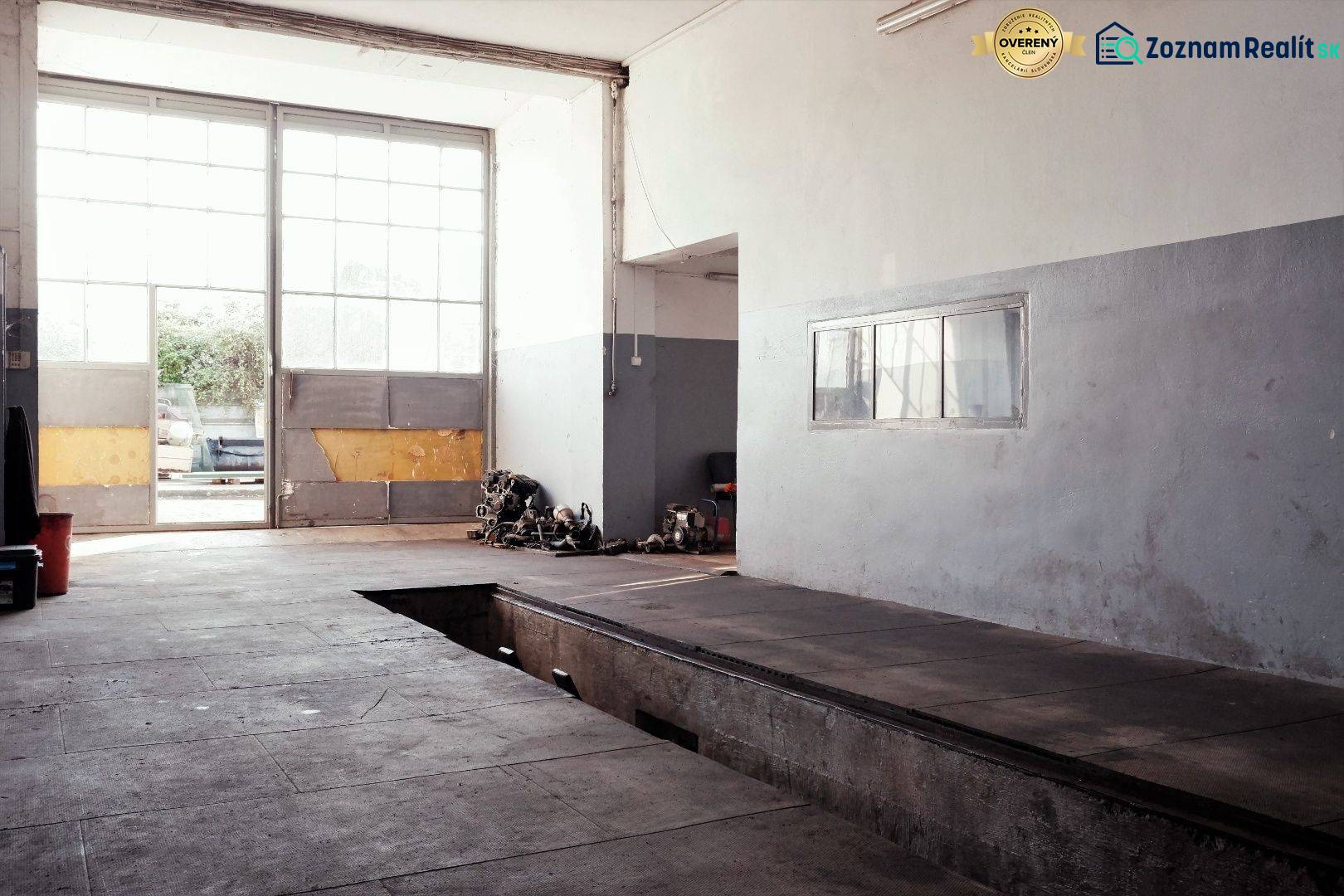 Produktionsräume mit großen Fenstern, einem Garagentor und einem Boden mit Holzdekor.