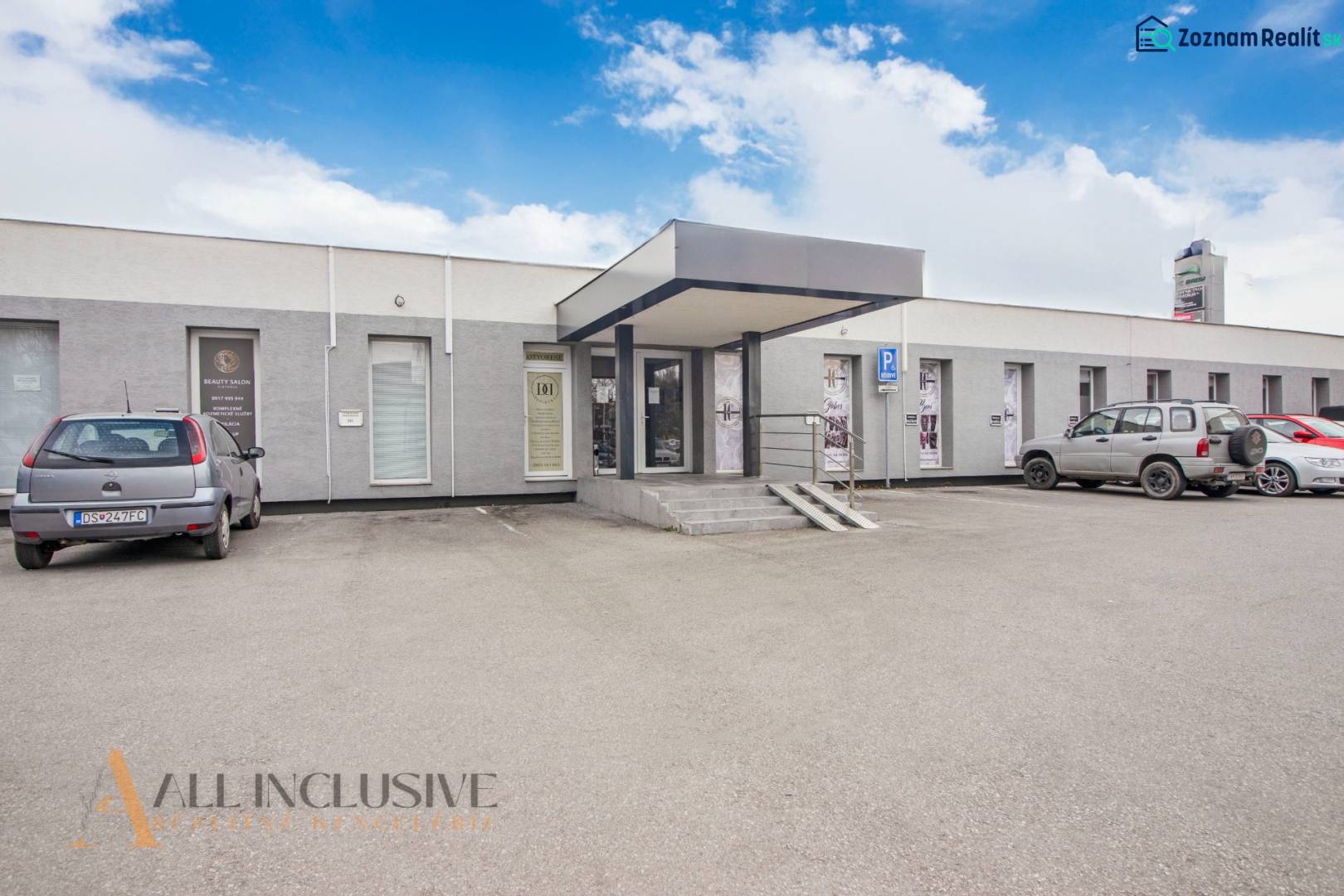 Einstöckiges Gebäude mit Geschäftsräumen in der Vajanského-Straße, Parkplatz und Autos vor dem Eingang.