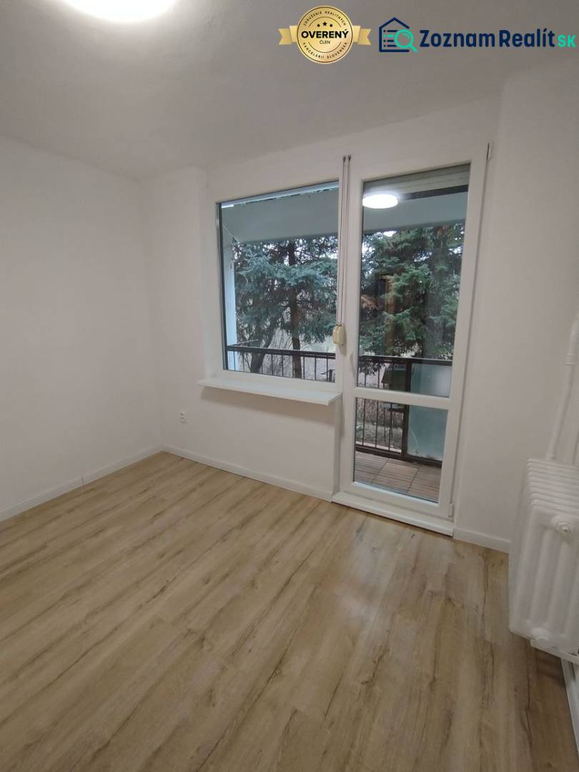 Ein Zimmer mit hellen Wänden, einem Boden in Holzoptik und Blick ins Grüne.