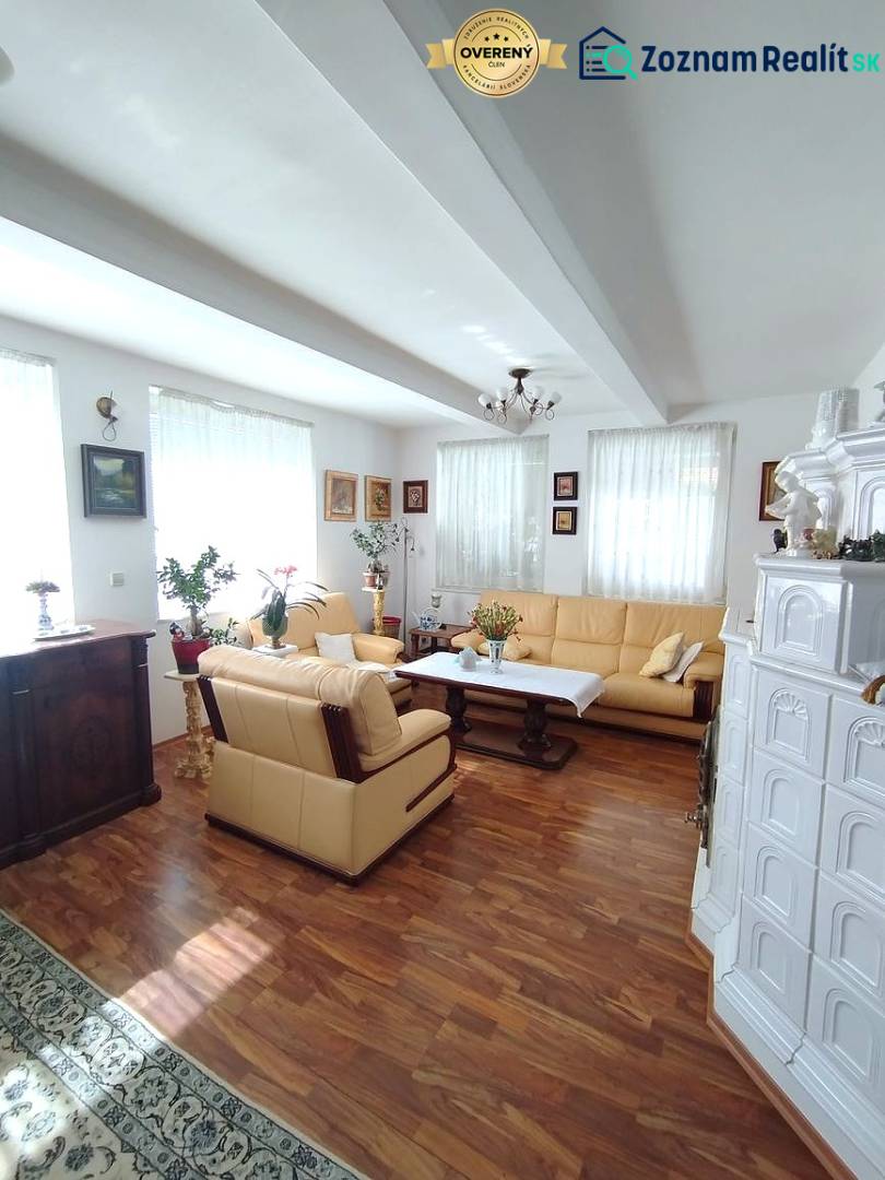 Wohnzimmer eines Einfamilienhauses mit Holzboden, Kamin und bequemer Sitzgarnitur.