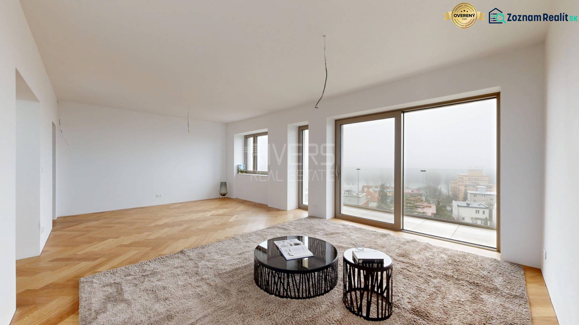 Wohnzimmer in einem Einfamilienhaus mit Holzboden und großen Fenstern.